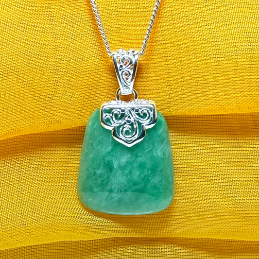 A real green jade necklace with a large shaped and patterned top pendant