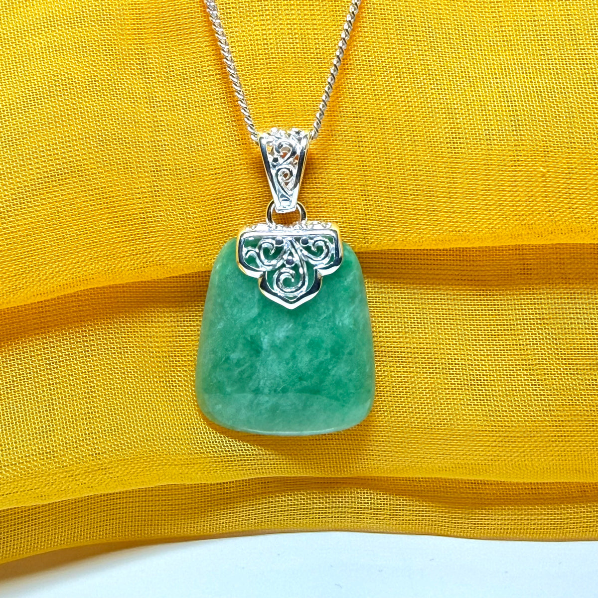 A beautiful real green jade necklace with a large shaped and patterned top pendant with chain
