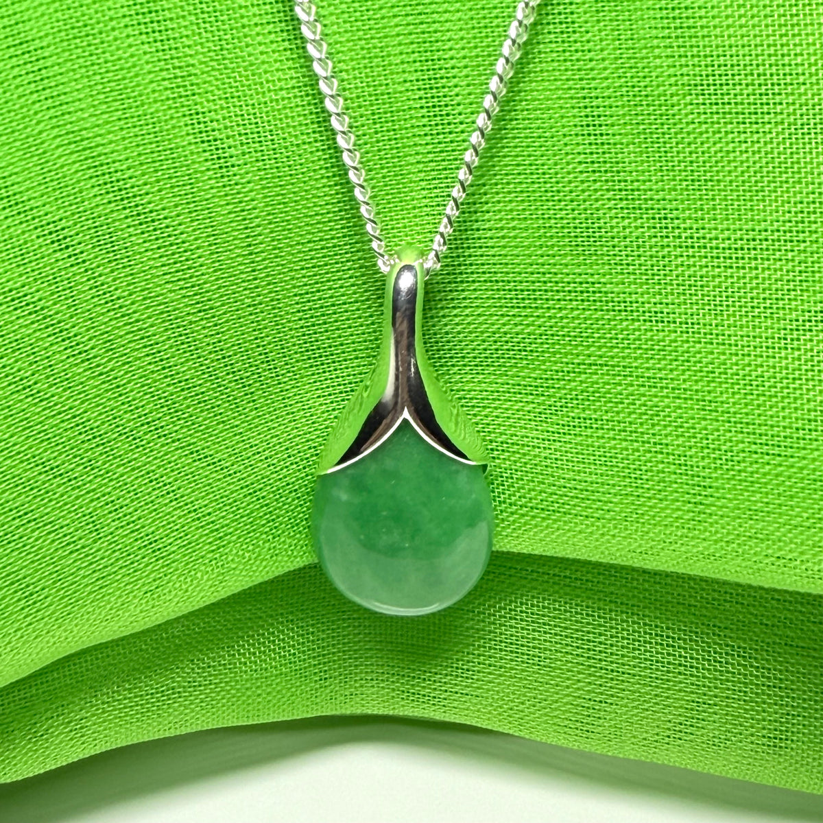 A gorgeous real green jade necklace in a tear drop or pear shaped with a chain as well