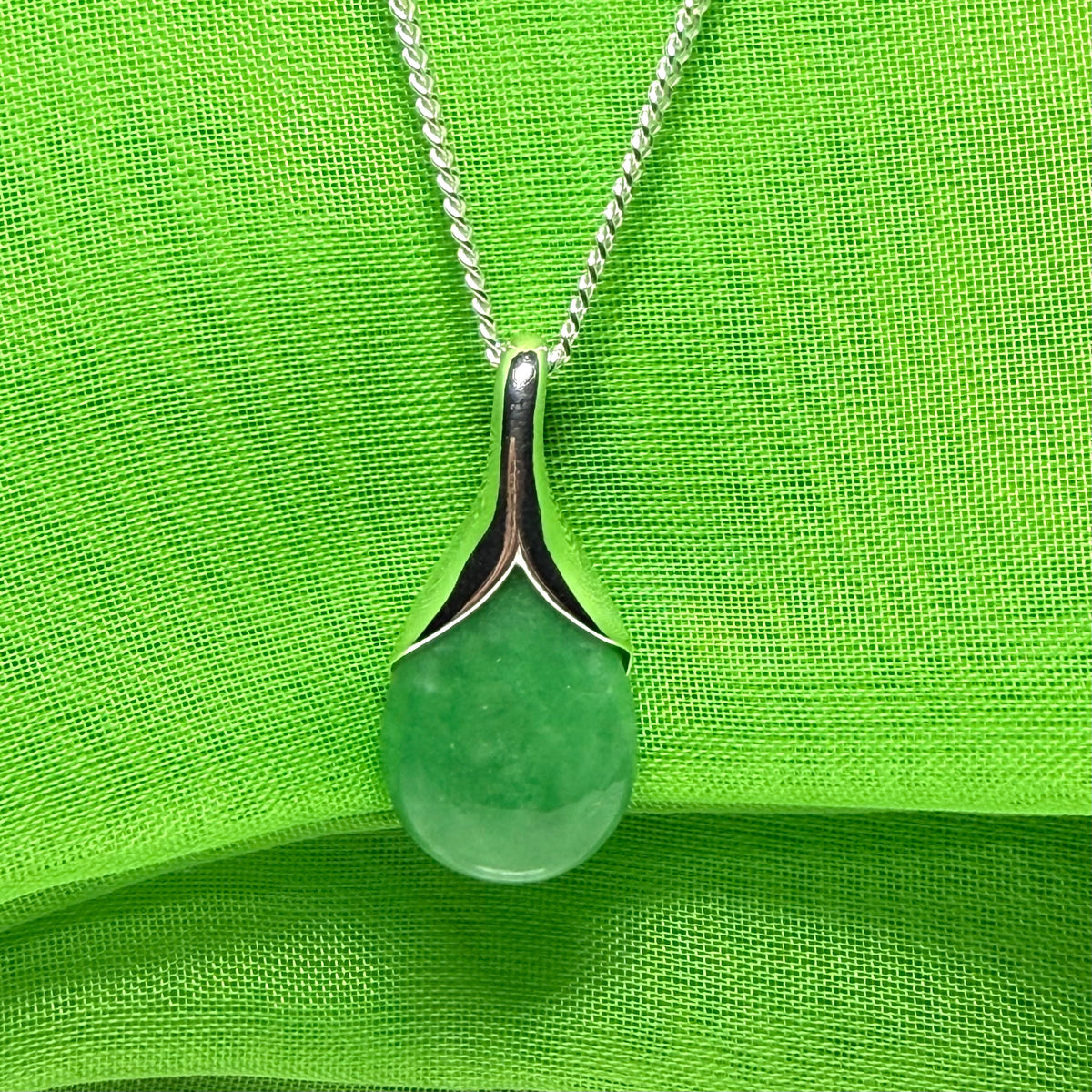 A gorgeous real green jade necklace in a tear drop or pear shaped with a chain as well