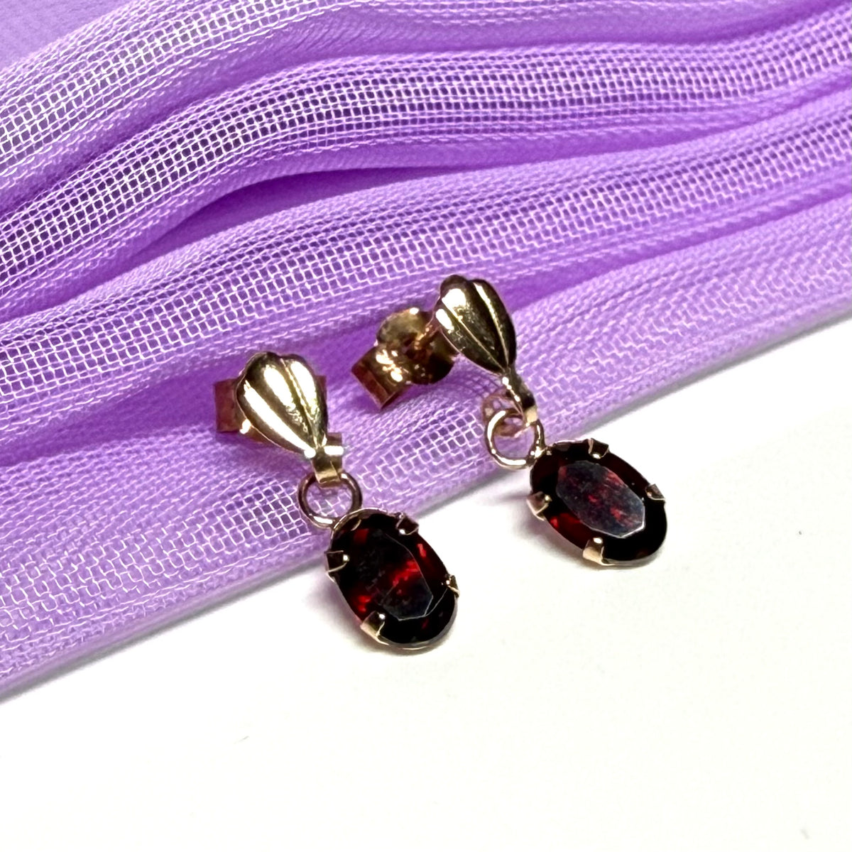 A pair of real red garnet drop earrings oval shaped yellow gold