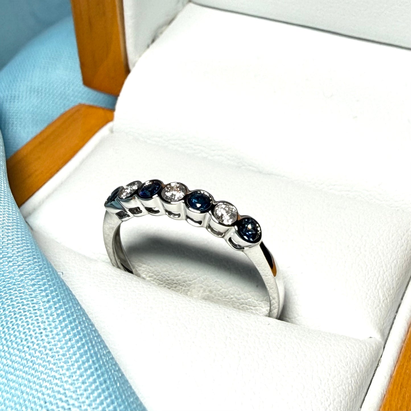 A real blue sapphire and diamond white gold eternity ring smooth setting