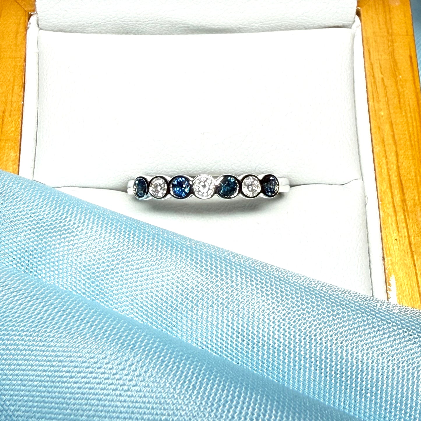 A real blue sapphire and diamond white gold eternity ring smooth setting