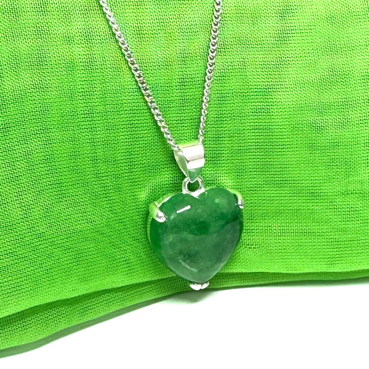 A real dark green jade pendant necklace heart shape sterling silver with a chain included with it