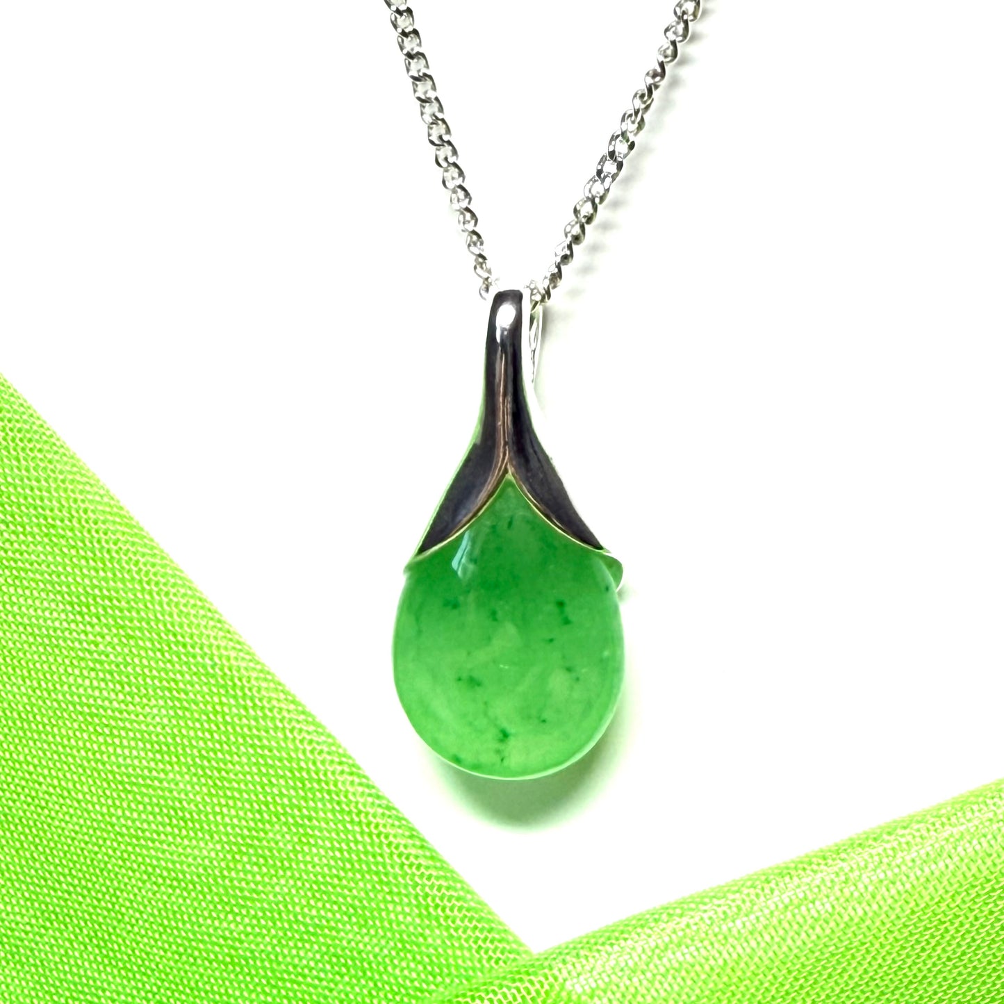 A real green jade necklace in a tear drop or pear shaped with a chain included