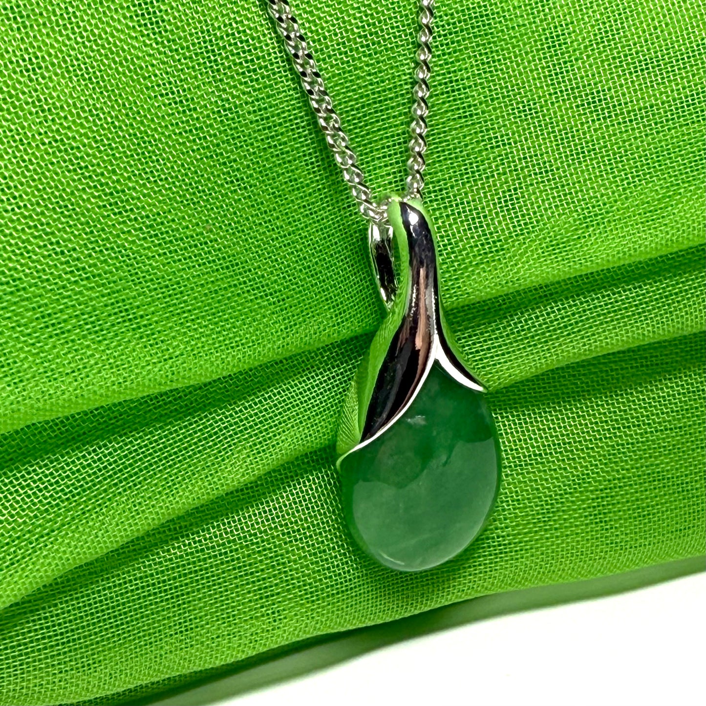 A real green jade necklace in a teardrop or a pear shape including a chain