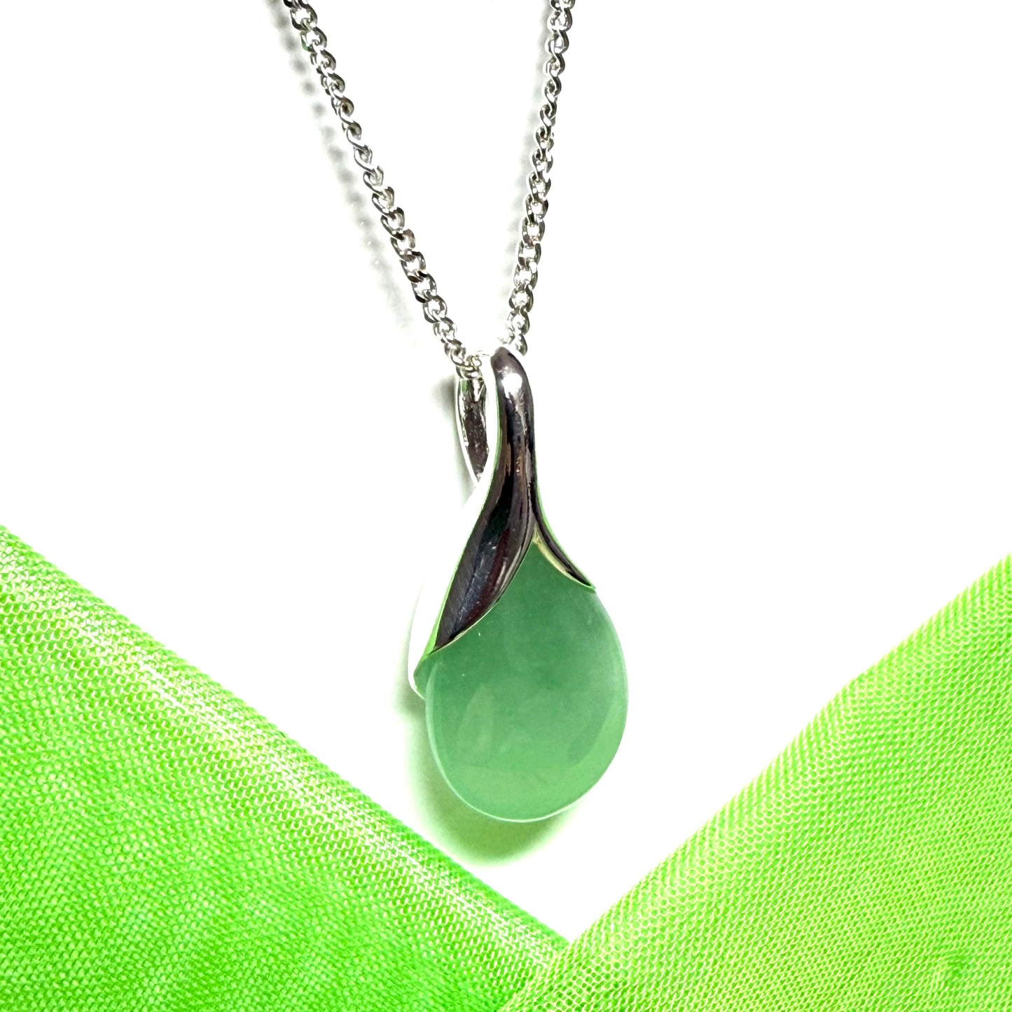 A real green jade necklace in a teardrop or a pear shape including a solid chain