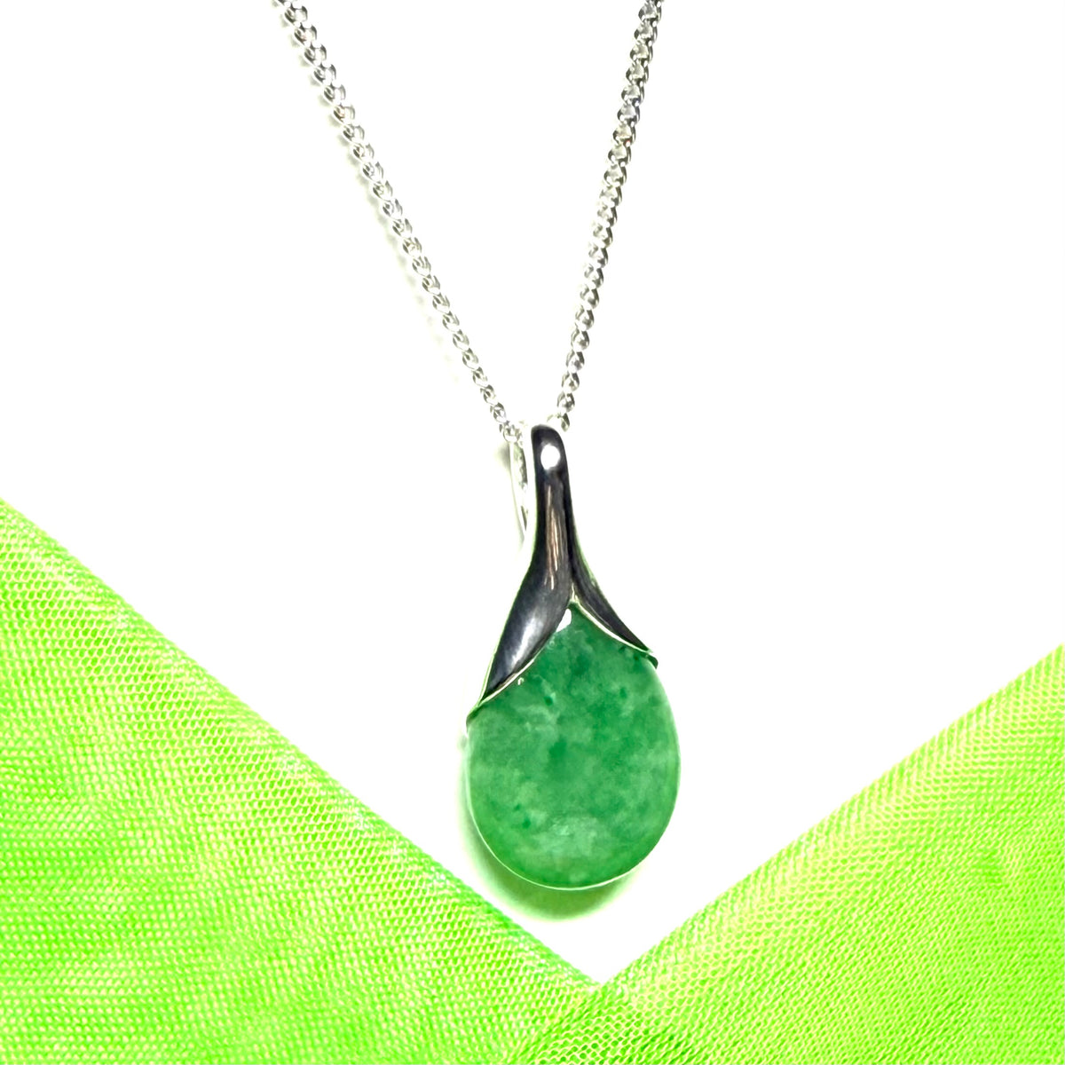 A real green jade necklace in a teardrop or pear shaped including a solid chain
