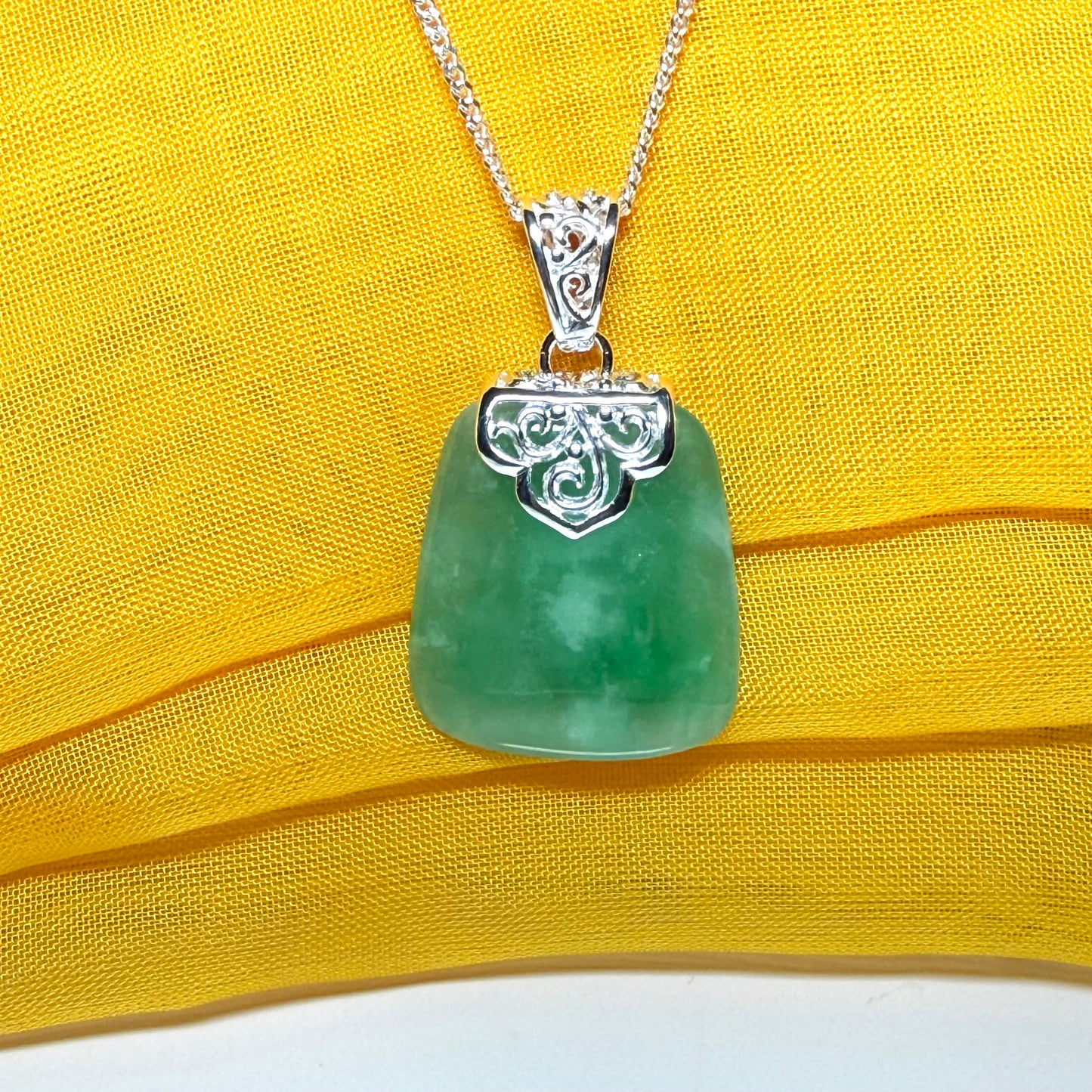 A real green jade necklace large shaped with a patterned top pendant with chain