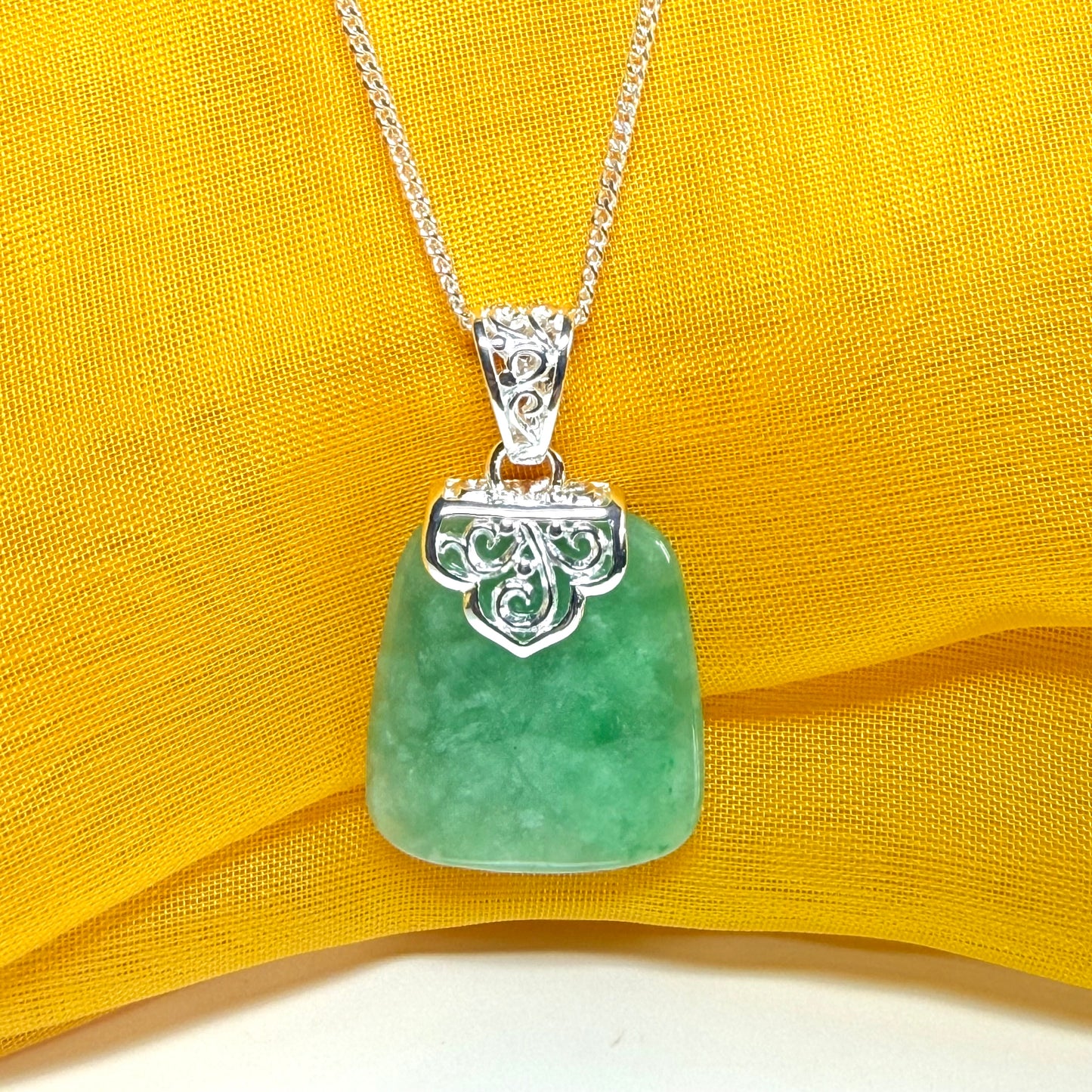 A real green jade necklace sterling silver large cushion shaped including a curb chain, a beautiful pendant