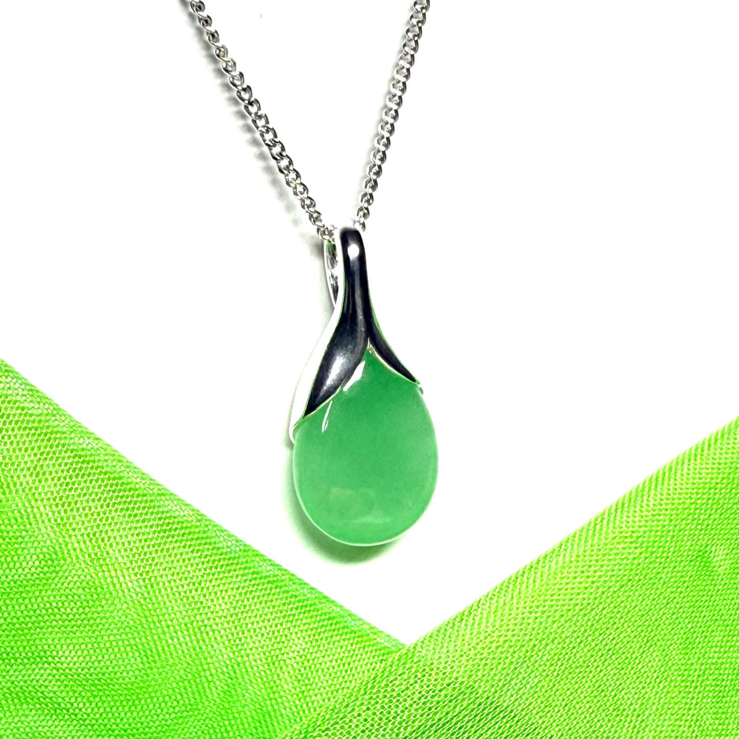 A real green jade necklace teardrop with a pear shaped pendant to it