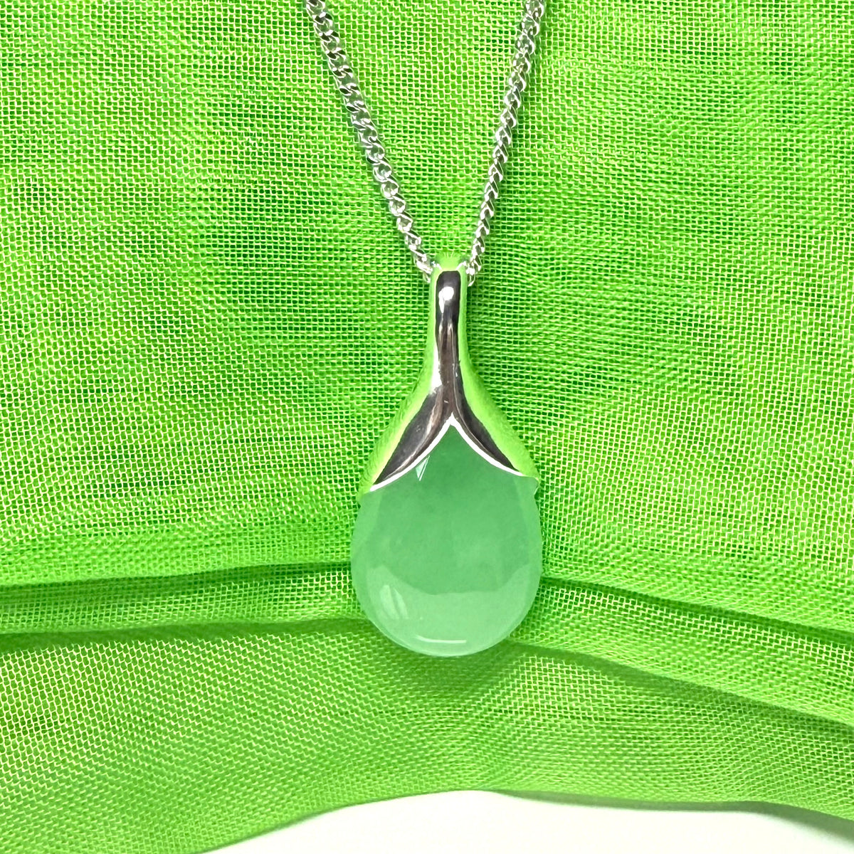 A real green jade necklace teardrop with a pear shaped pendant to it