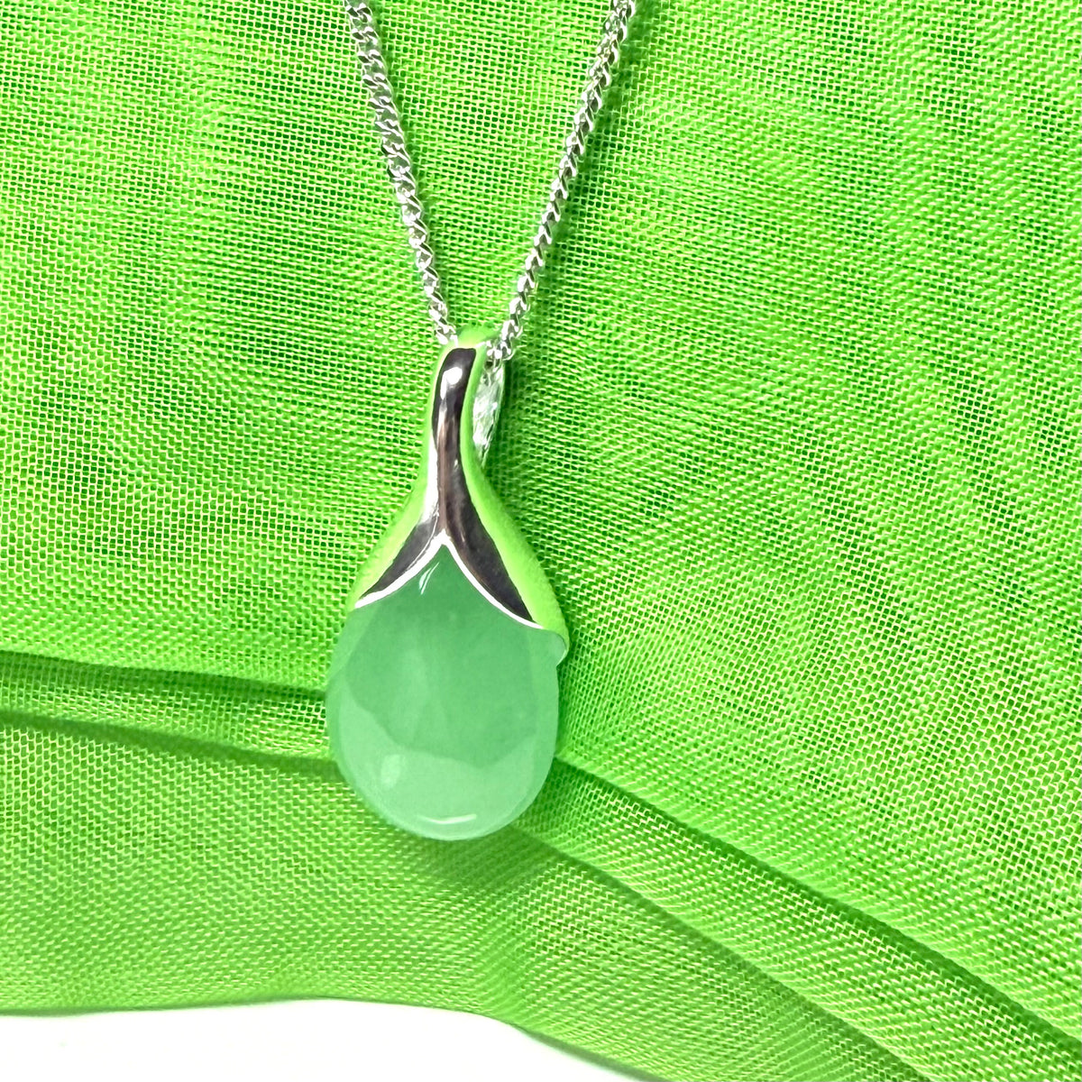 A real green jade necklace teardrop with a pear shaped pendant to it