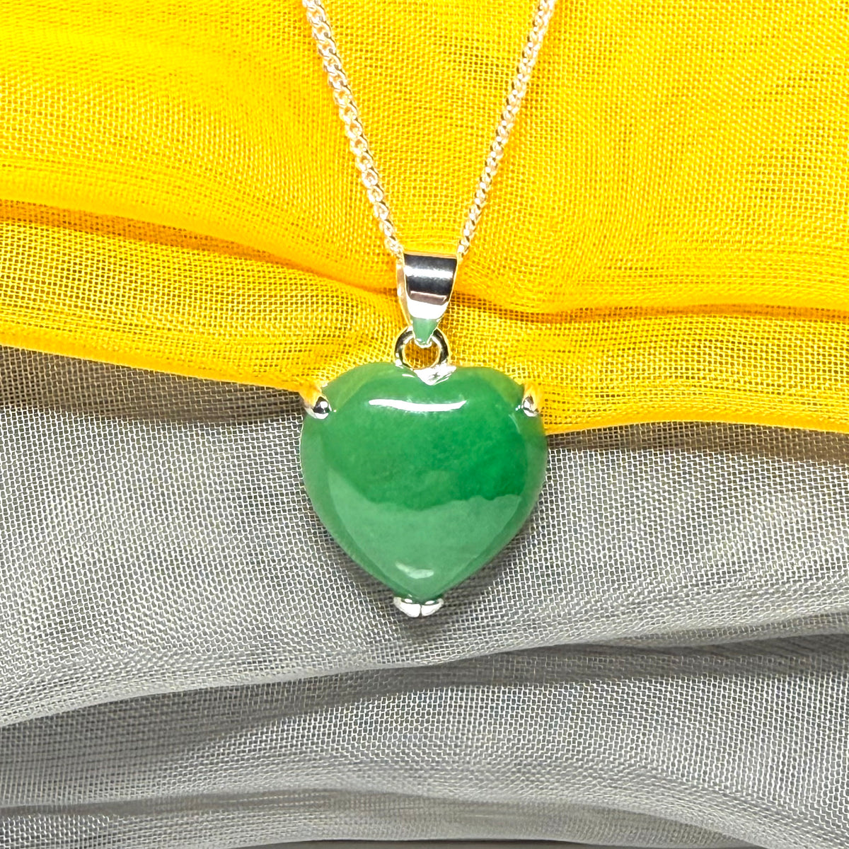 A real green jade pendant heart shaped sterling silver, a traditional design