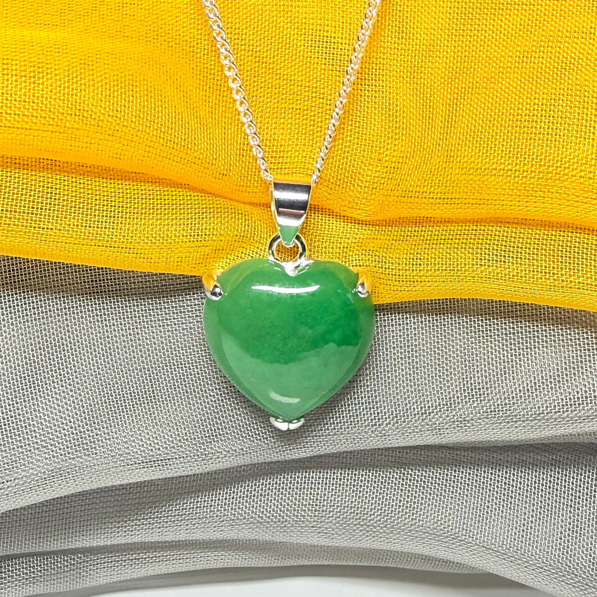 A real green jade pendant heart shaped sterling silver, a traditional design