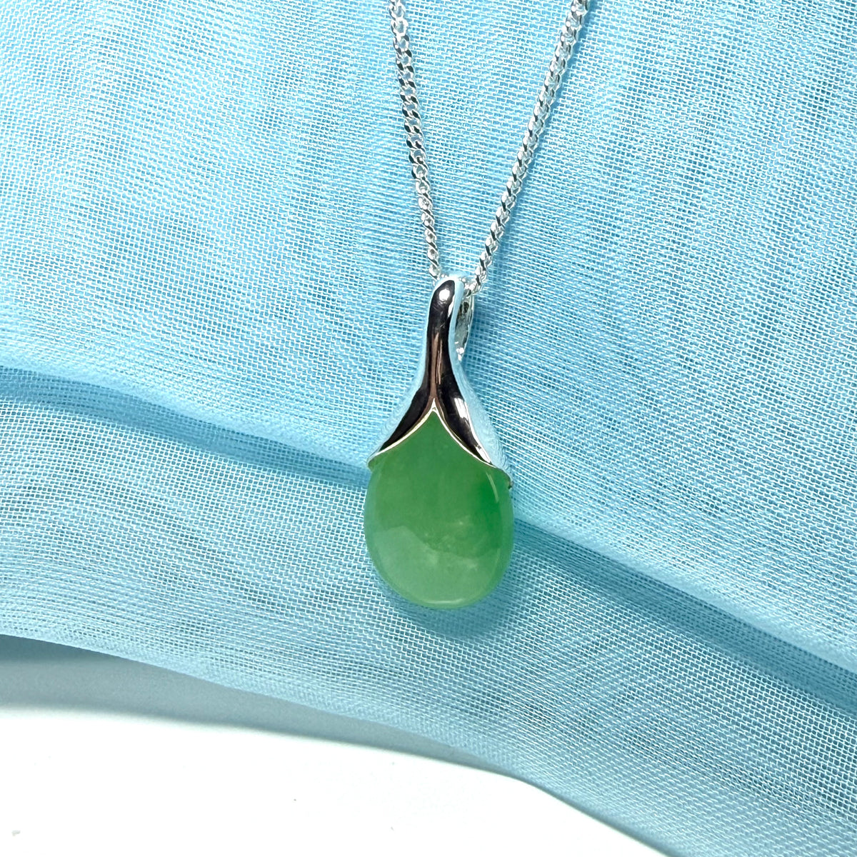 A real green jade pendant necklace in a distinctive teardrop shape or pear shaped design