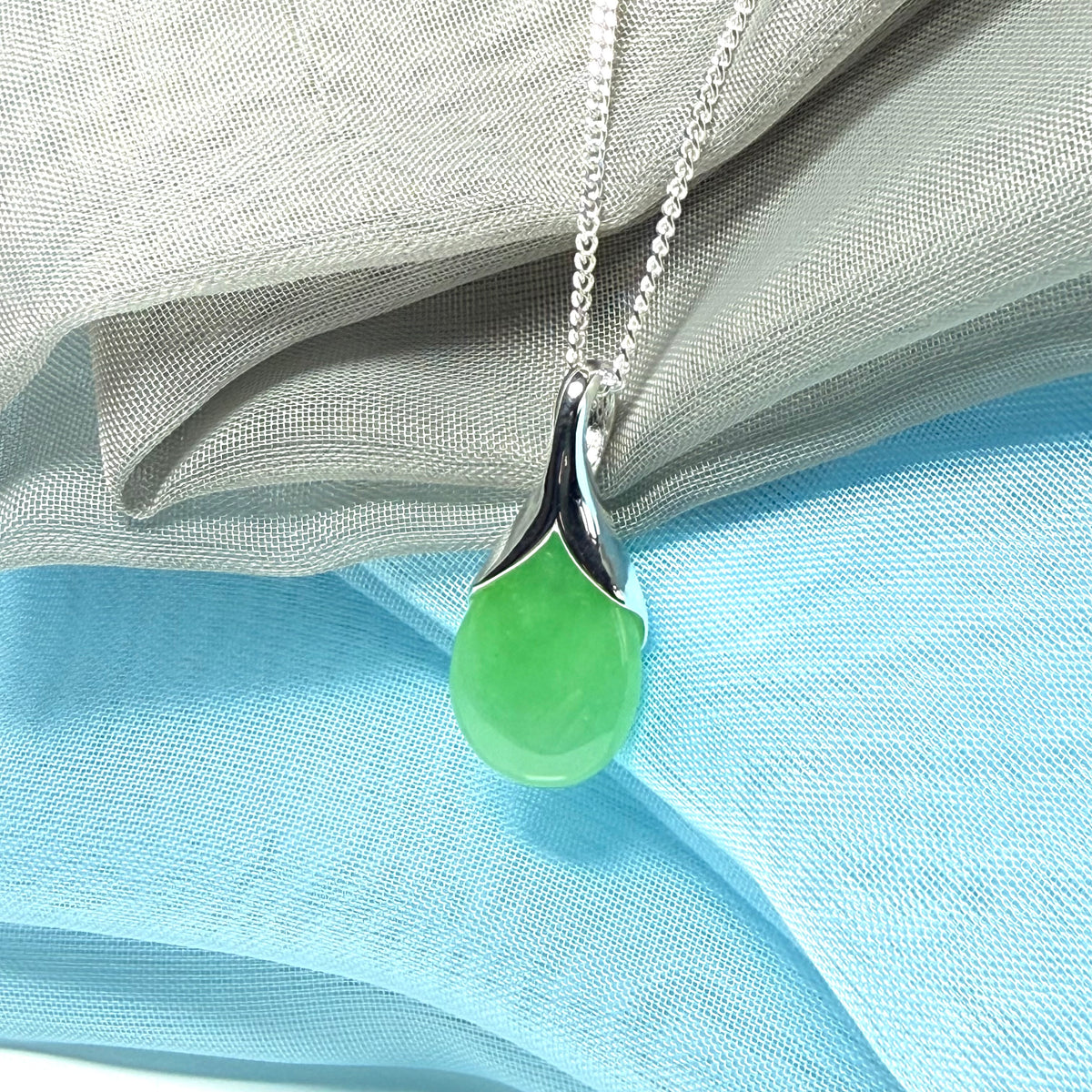 A real jade pendant in a teardrop shape or pear shaped designed green necklace with chain