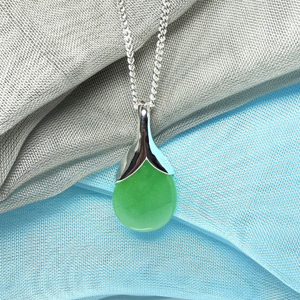 A real jade pendant in a teardrop shape or pear shaped designed green necklace with chain