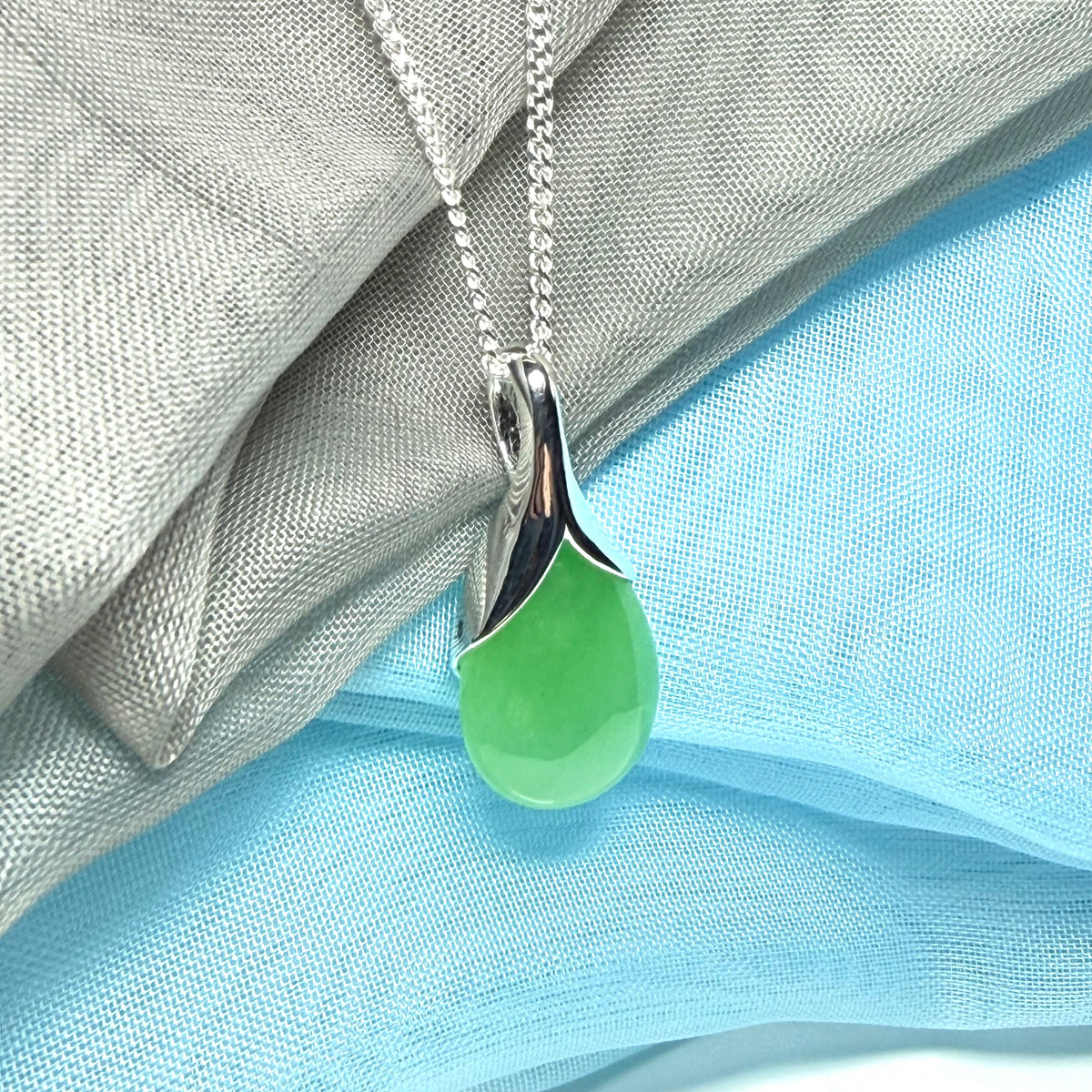 A real jade pendant in a teardrop shape or pear shaped designed green necklace with chain