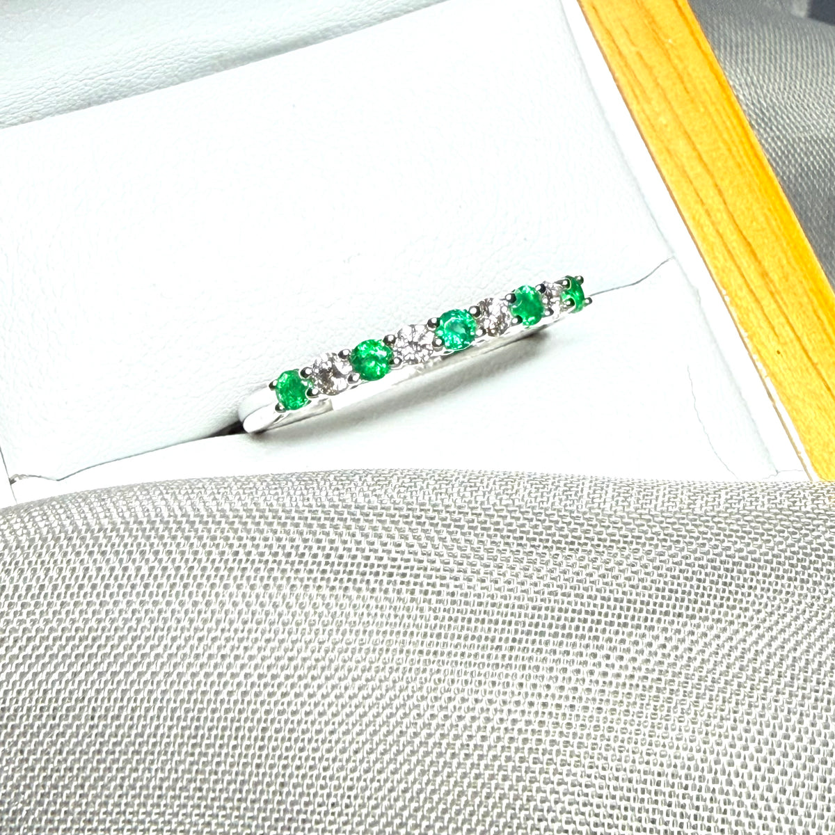 A stunning real emerald and diamond white gold eternity ring claw setting