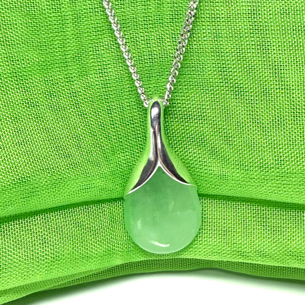 A stunning real green jade necklace in a teardrop or a pear shape including a solid curb chain