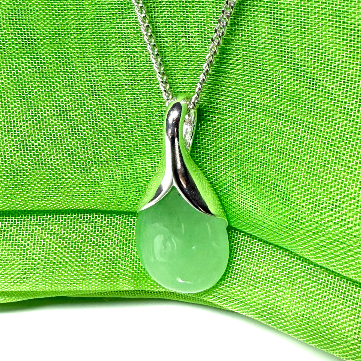 A stunning real green jade necklace in a teardrop or a pear shape including a solid curb chain