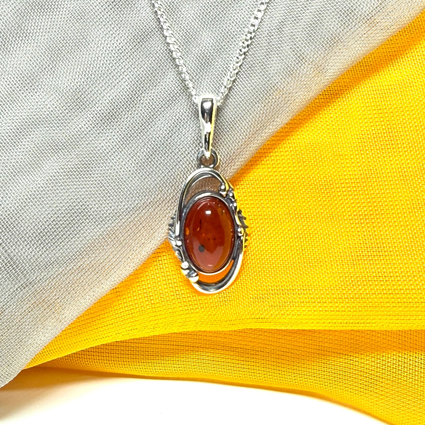 Orange real amber oval sterling silver necklace with a swirl set open pendant With chain