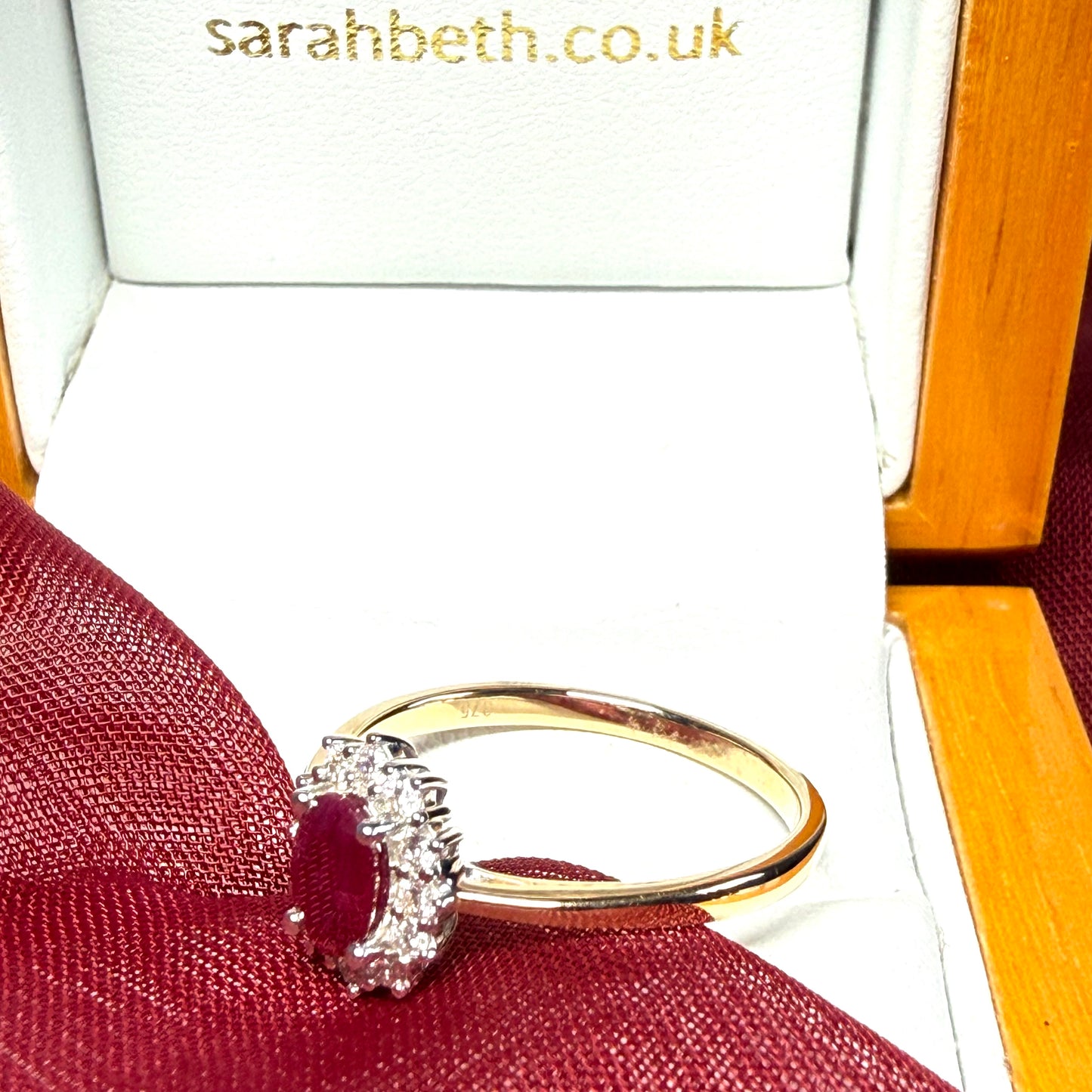 An oval red real ruby and diamond yellow gold cluster ring