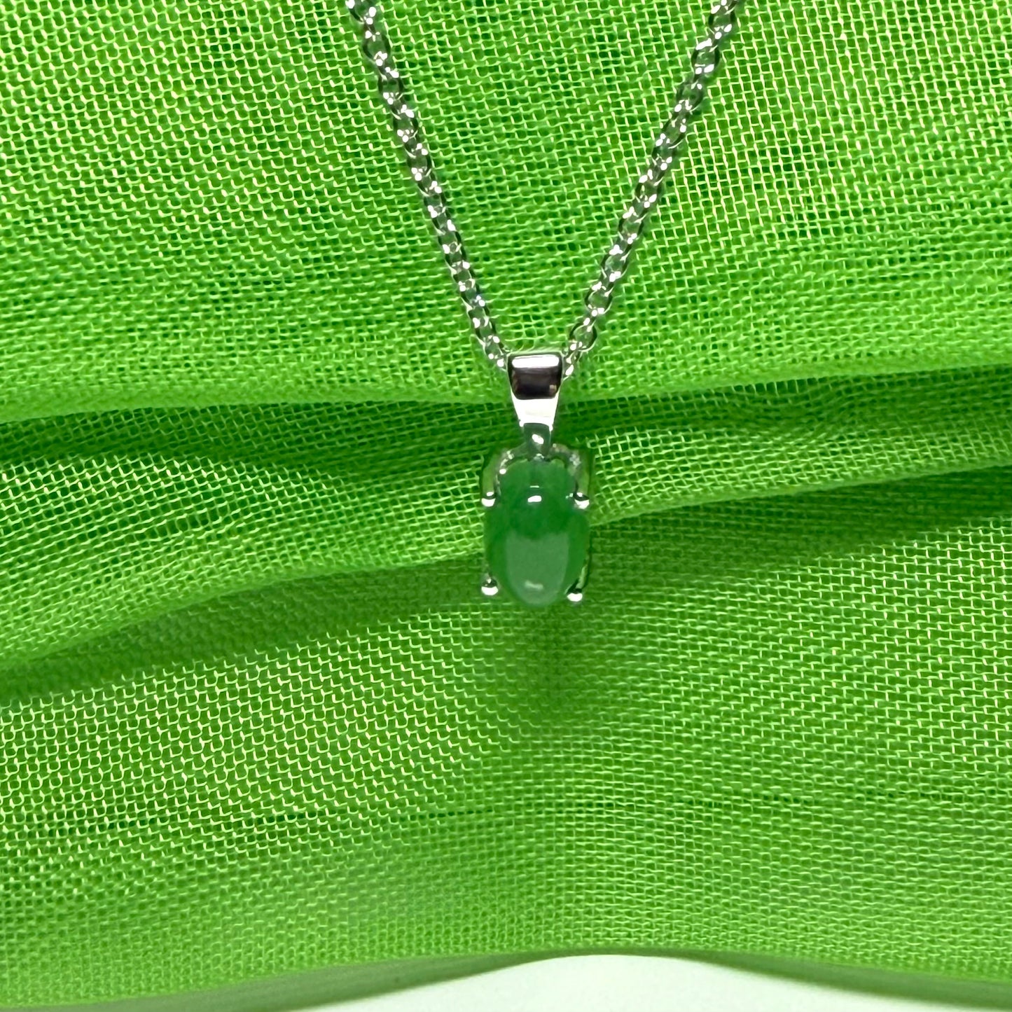 An oval shaped real green jade necklace white gold including chain