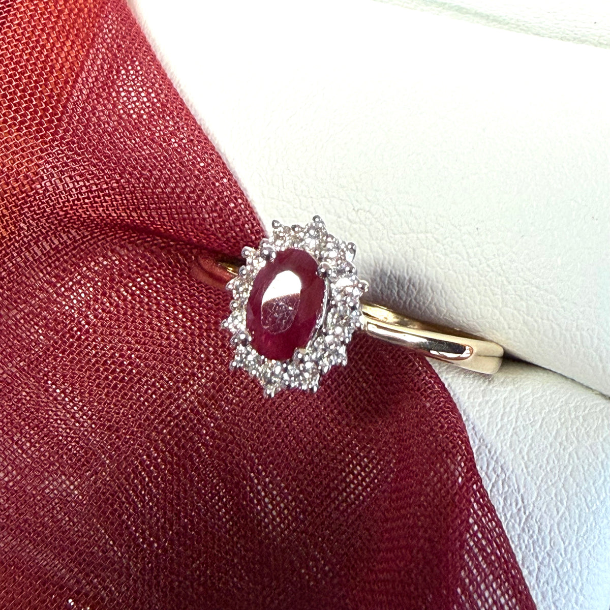 An oval red real ruby and diamond yellow gold cluster ring