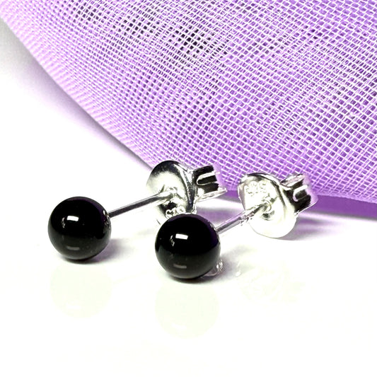 Real black onyx round ball stud earrings with silver posts on a white background