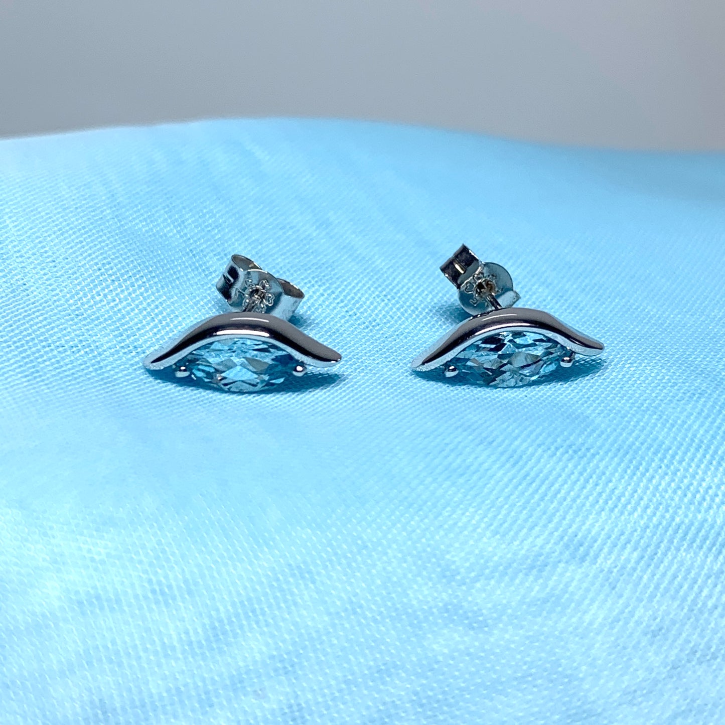 Blue topaz white gold marquise shaped fancy swirl stud earrings