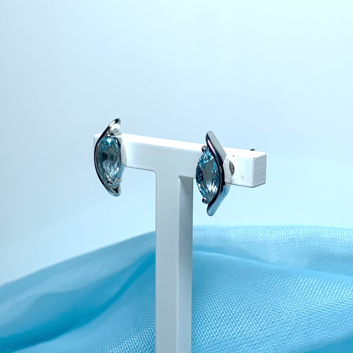 Blue topaz white gold marquise shaped fancy swirl stud earrings