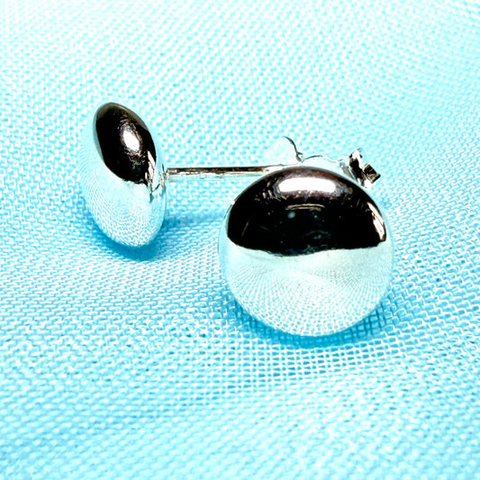 Silver earrings with black accents on a light blue textured background