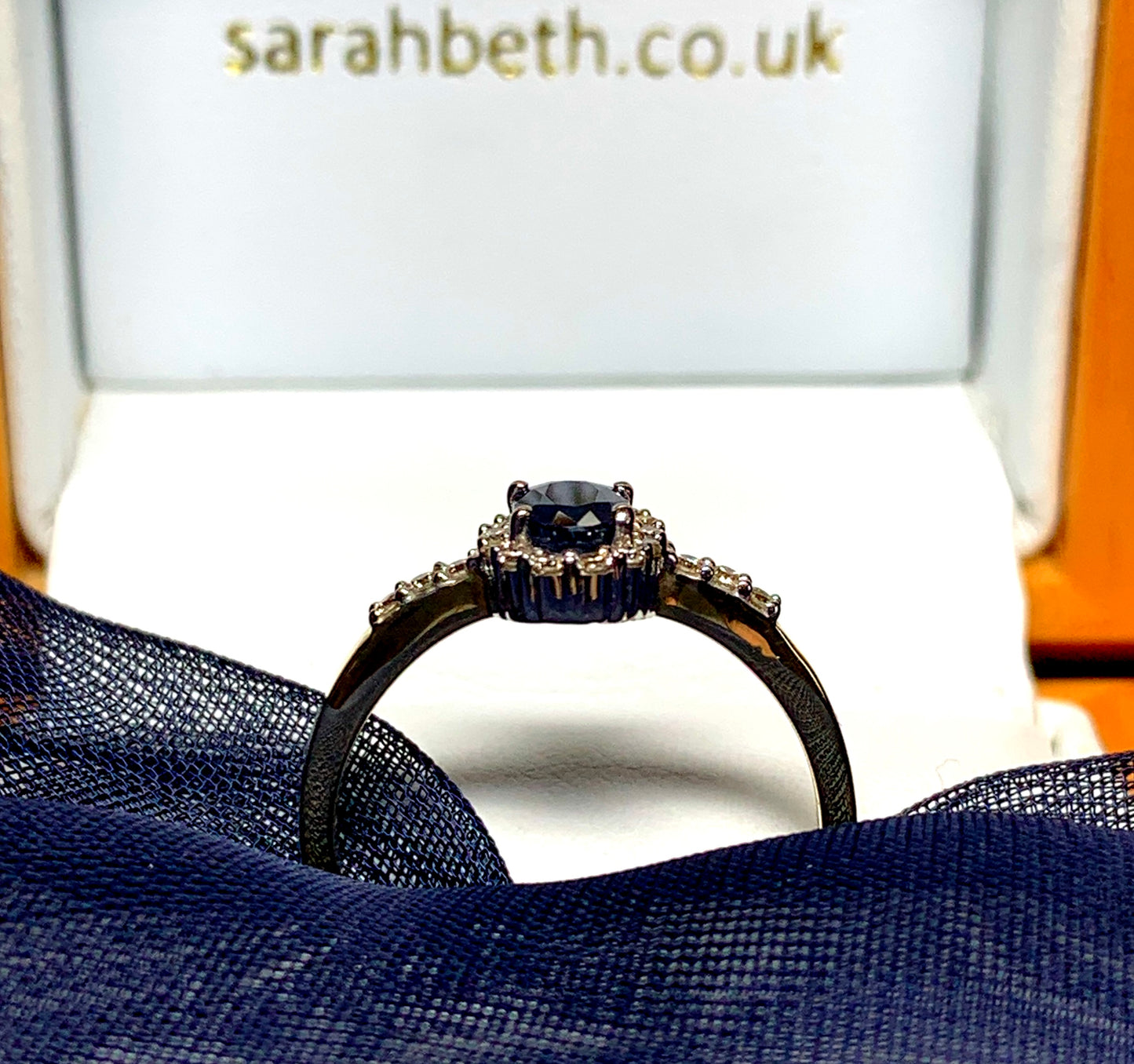 Dark blue sapphire diamond yellow gold oval cluster ring with diamond set shoulders
