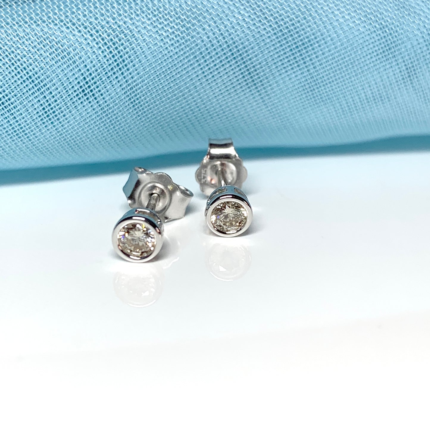 Diamond stud earrings rubbed over single stone smooth setting 25 Points