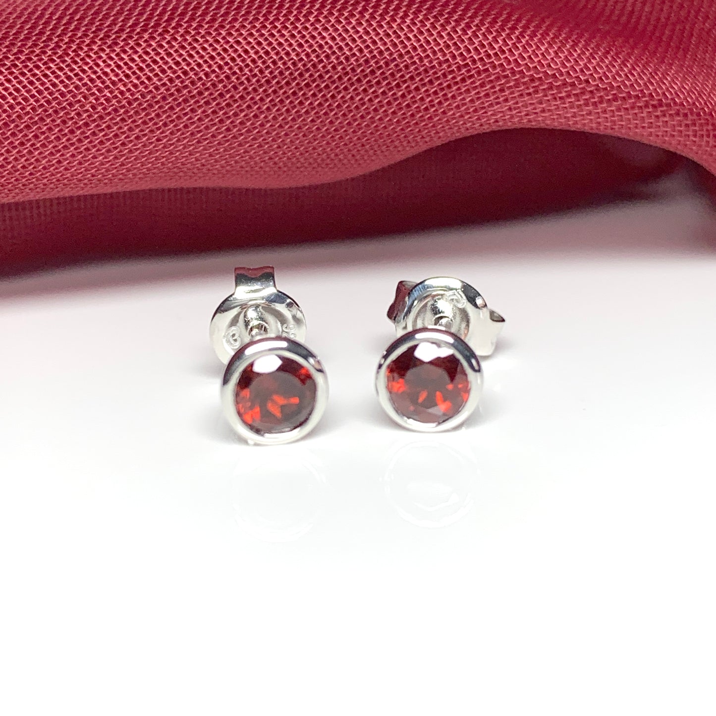 Garnet silver round stud earrings smooth rubbed over setting