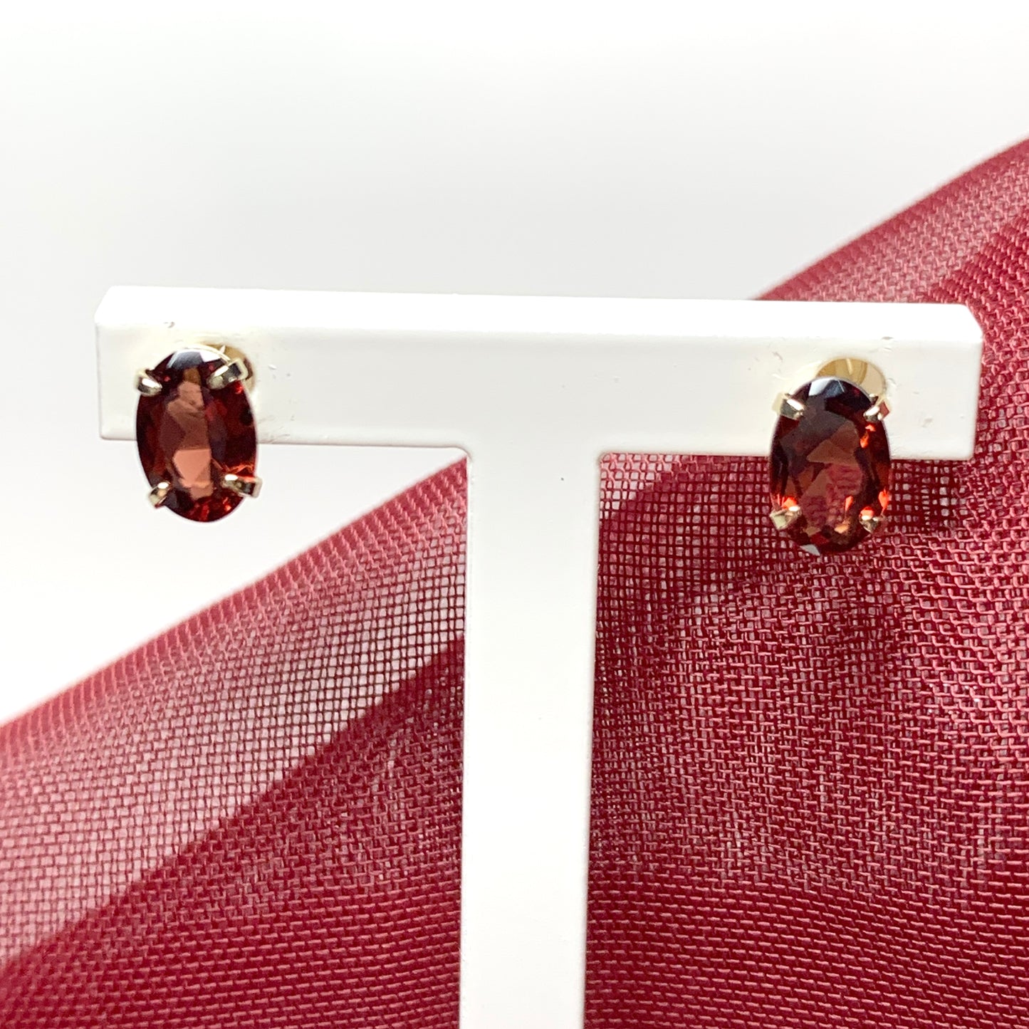 Garnet yellow gold oval four claw stud earrings