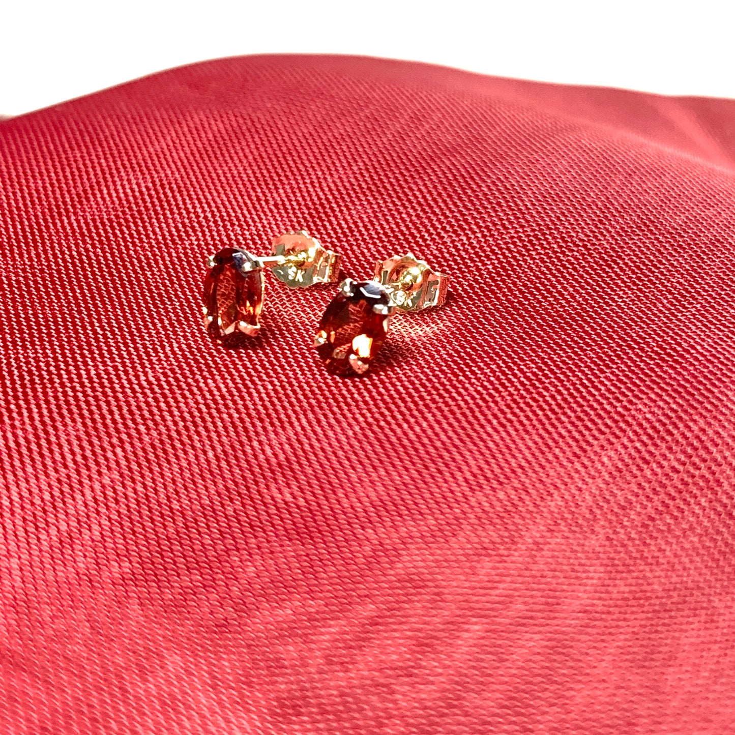 Garnet yellow gold oval four claw stud earrings