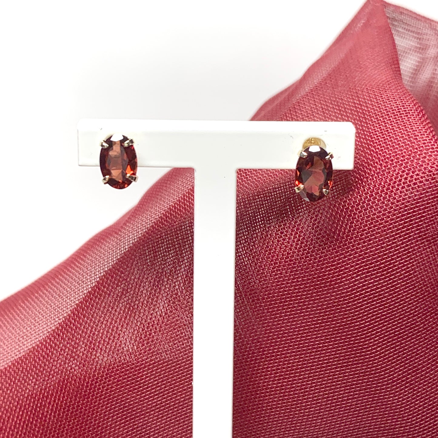 Garnet yellow gold oval four claw stud earrings