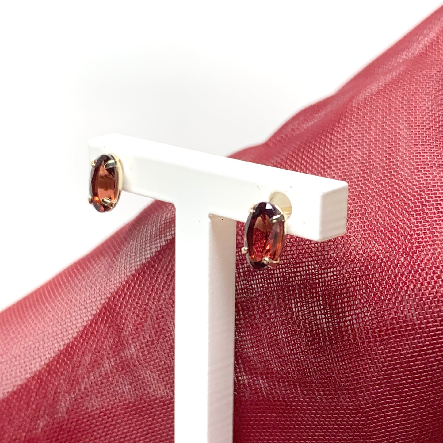 Garnet yellow gold oval four claw stud earrings