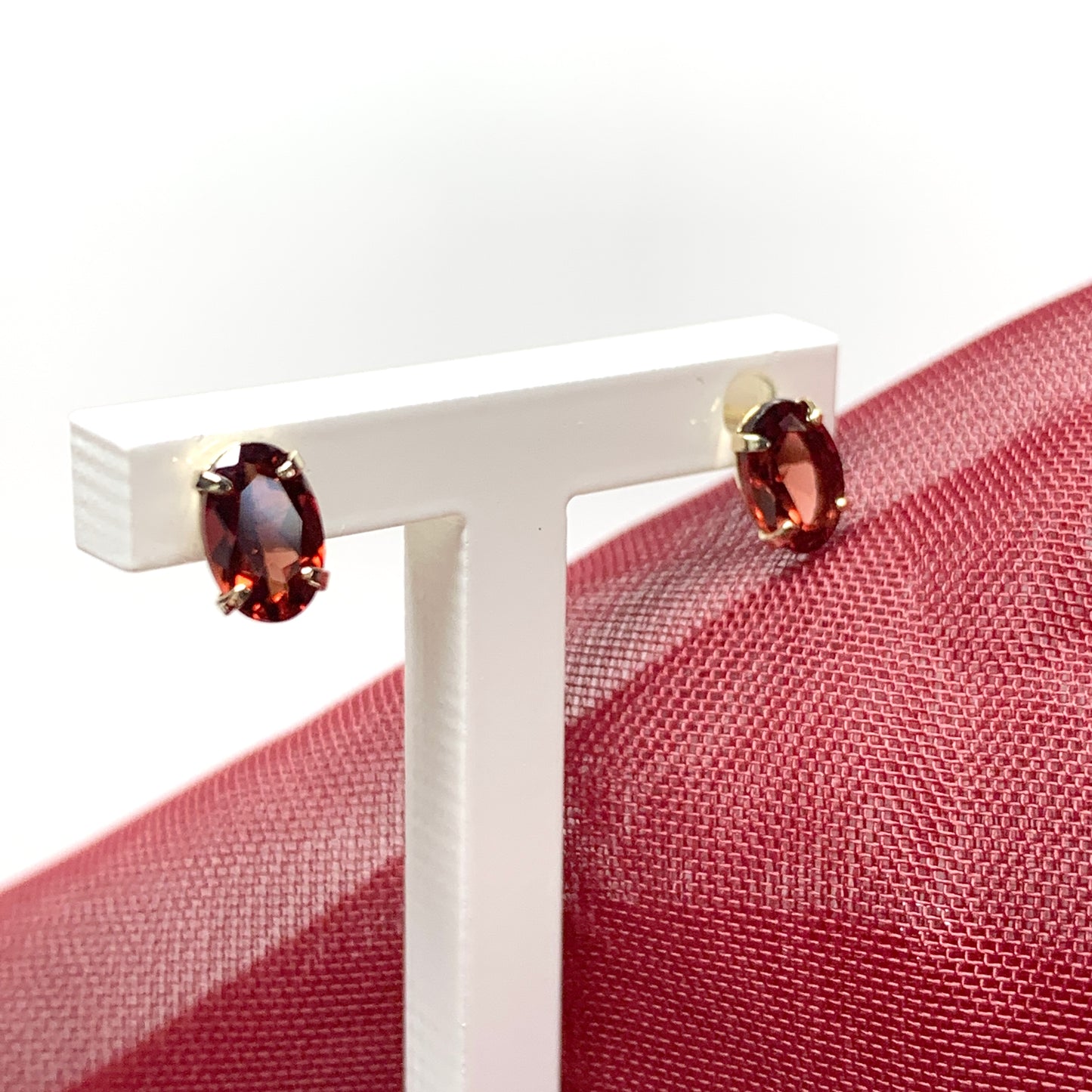 Garnet yellow gold oval four claw stud earrings