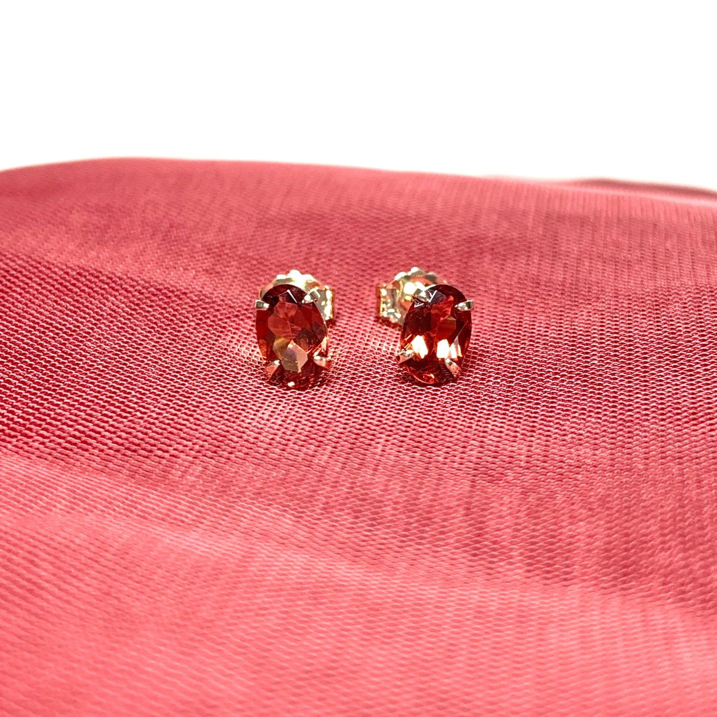 Garnet yellow gold oval four claw stud earrings