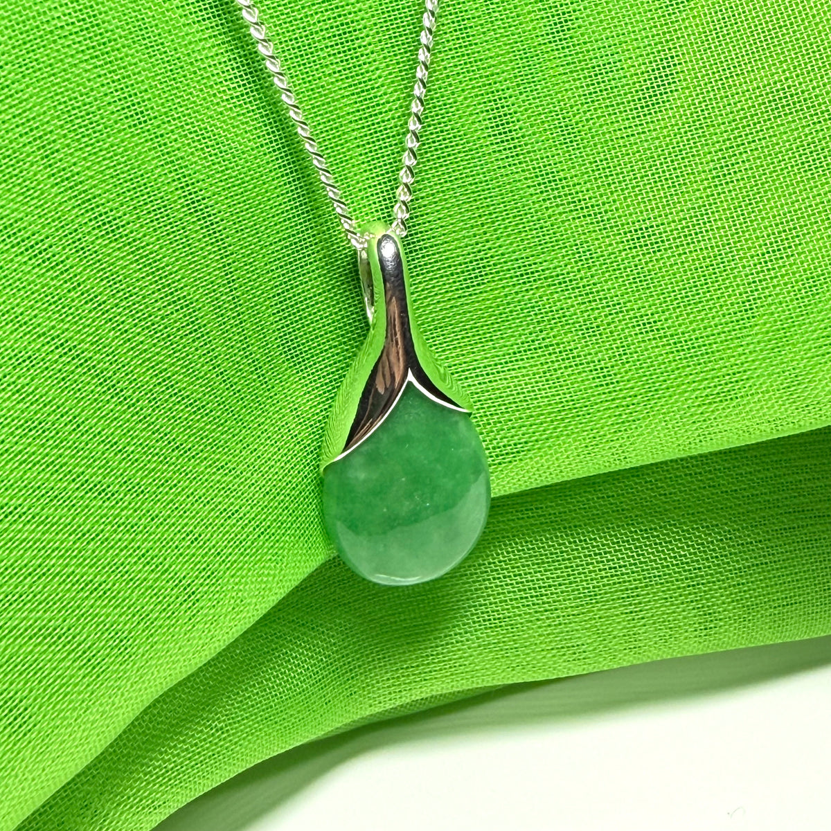 A gorgeous real green jade necklace in a tear drop or pear shaped with a chain as well
