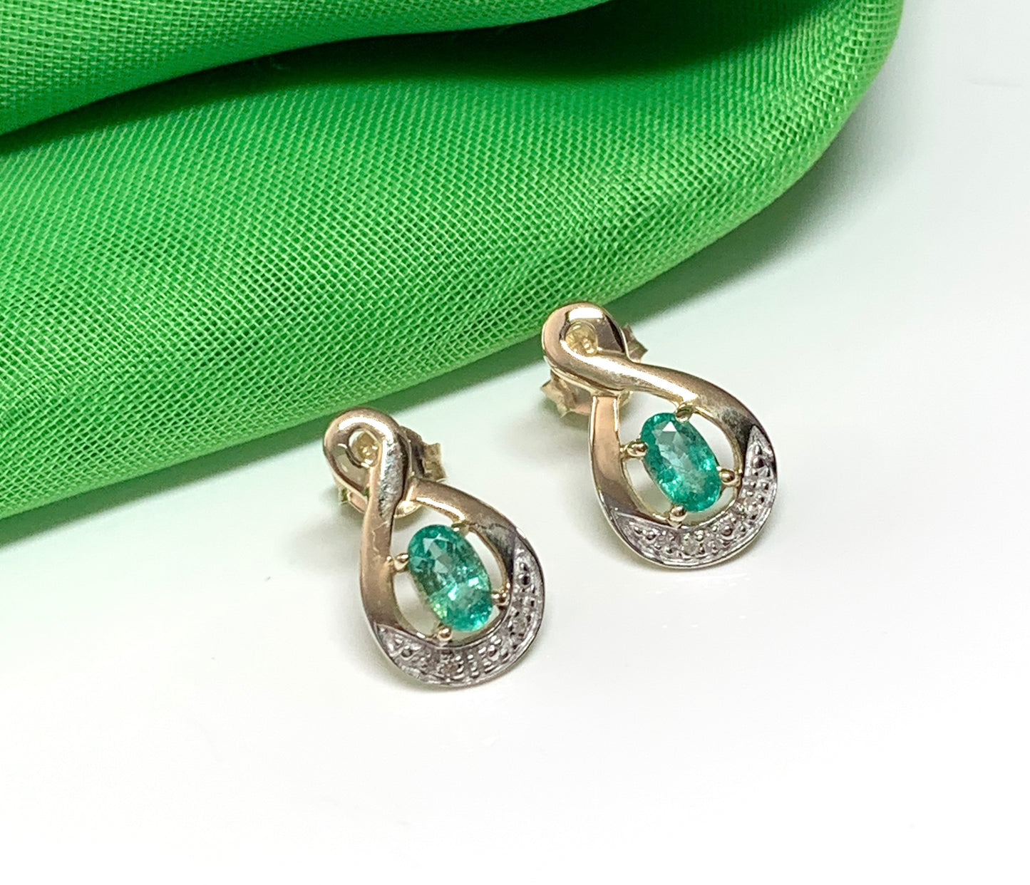 Green emerald and diamond oval shaped yellow gold stud earrings