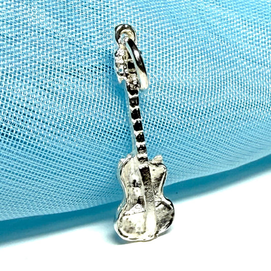 Silver guitar-shaped sterling silver charm on a light blue fabric background