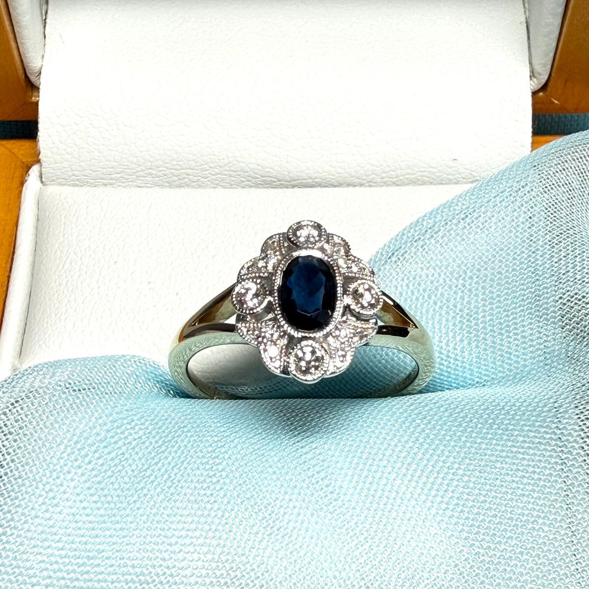 Dark blue sapphire and diamond yellow gold cluster ring