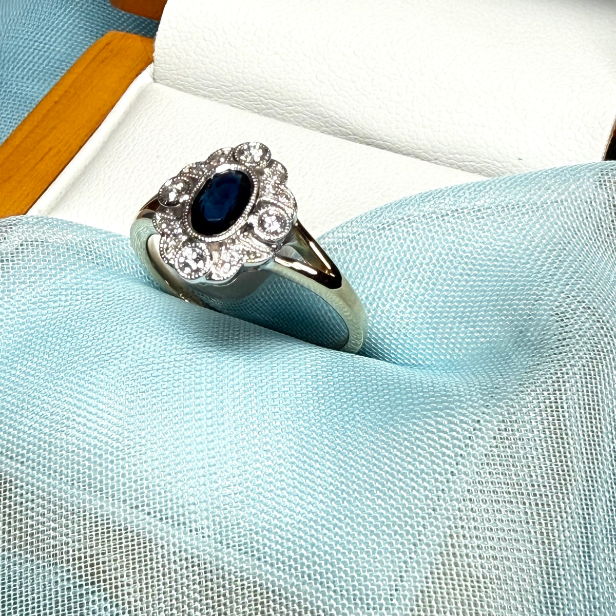 Dark blue sapphire and diamond yellow gold cluster ring