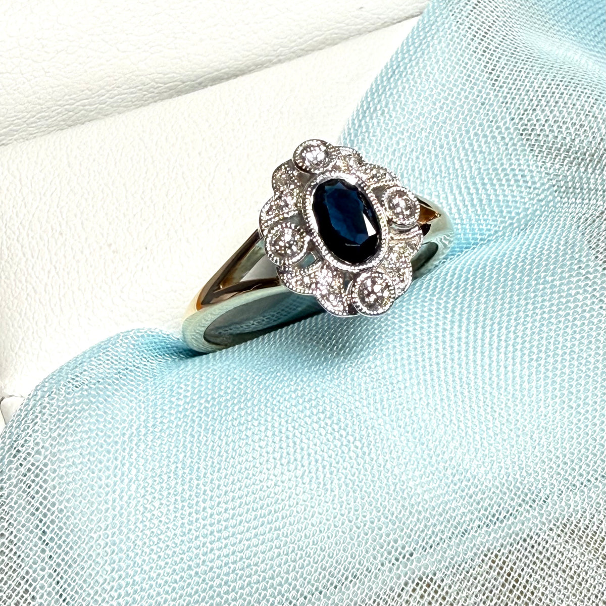 Dark blue sapphire and diamond yellow gold cluster ring