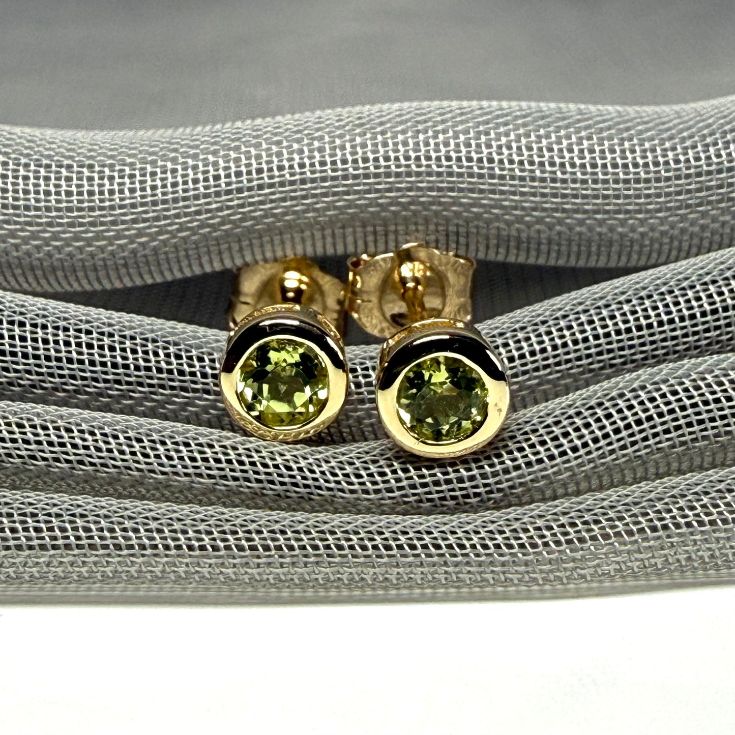 Pair of real green peridot earrings round yellow gold stud smooth rubbed over setting